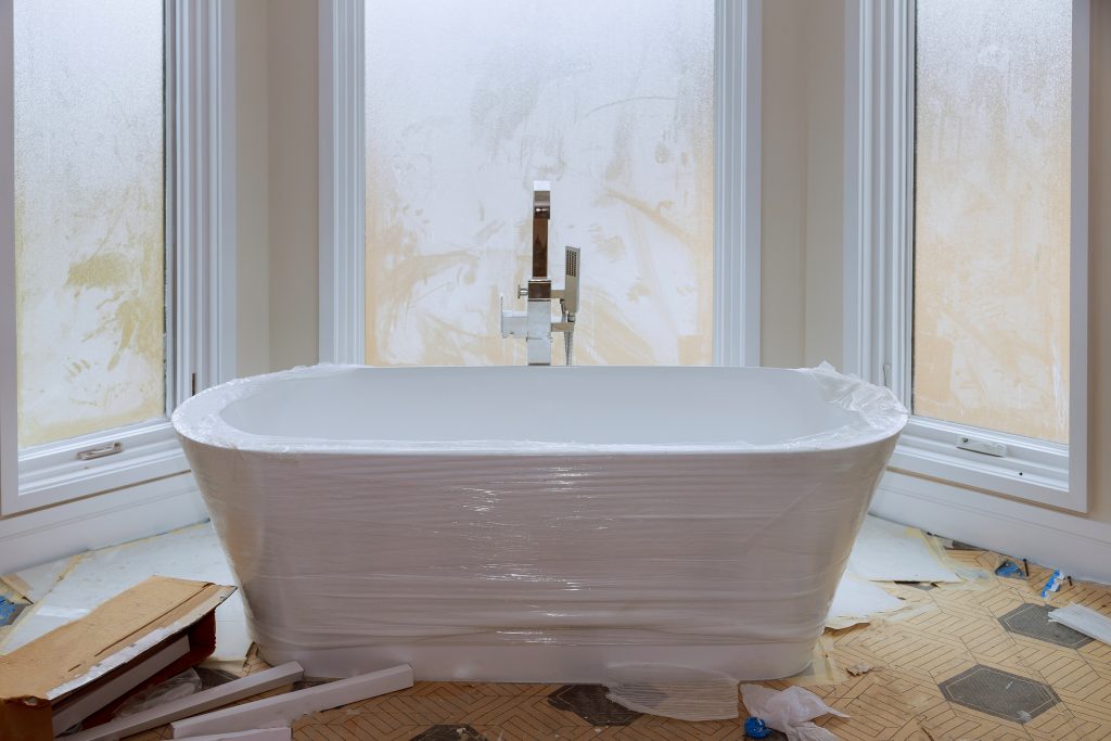 The Only 2026 Bathroom Remodel Trends & DIY Design Support That Matter 1 a new bathtub wrapped in plastic in a bathroom under construction